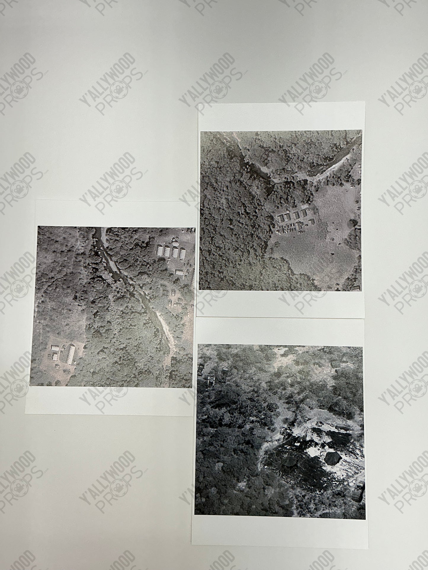 Three black and white aerial photographs showing buildings and vegetation from above, arranged on white backing paper.