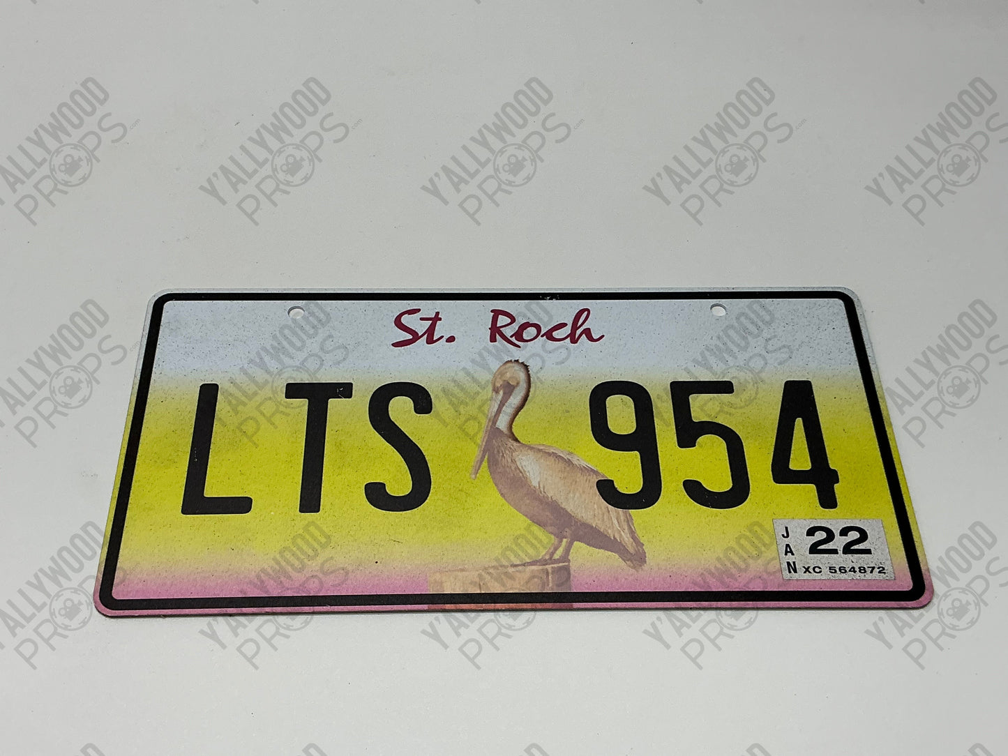 Black Adam decorative license plate with "St. Rock" and "LTS 954" text, featuring a pelican illustration on yellow and pink g