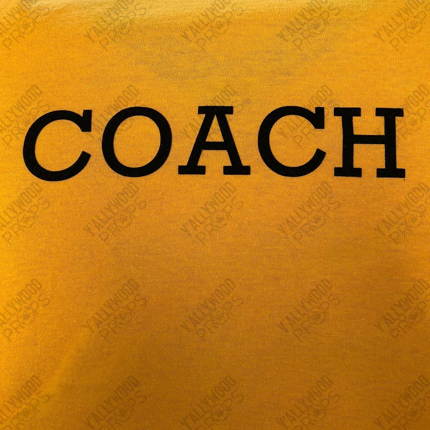 Yellow baseball shirt with black "COACH" text printed across the chest.