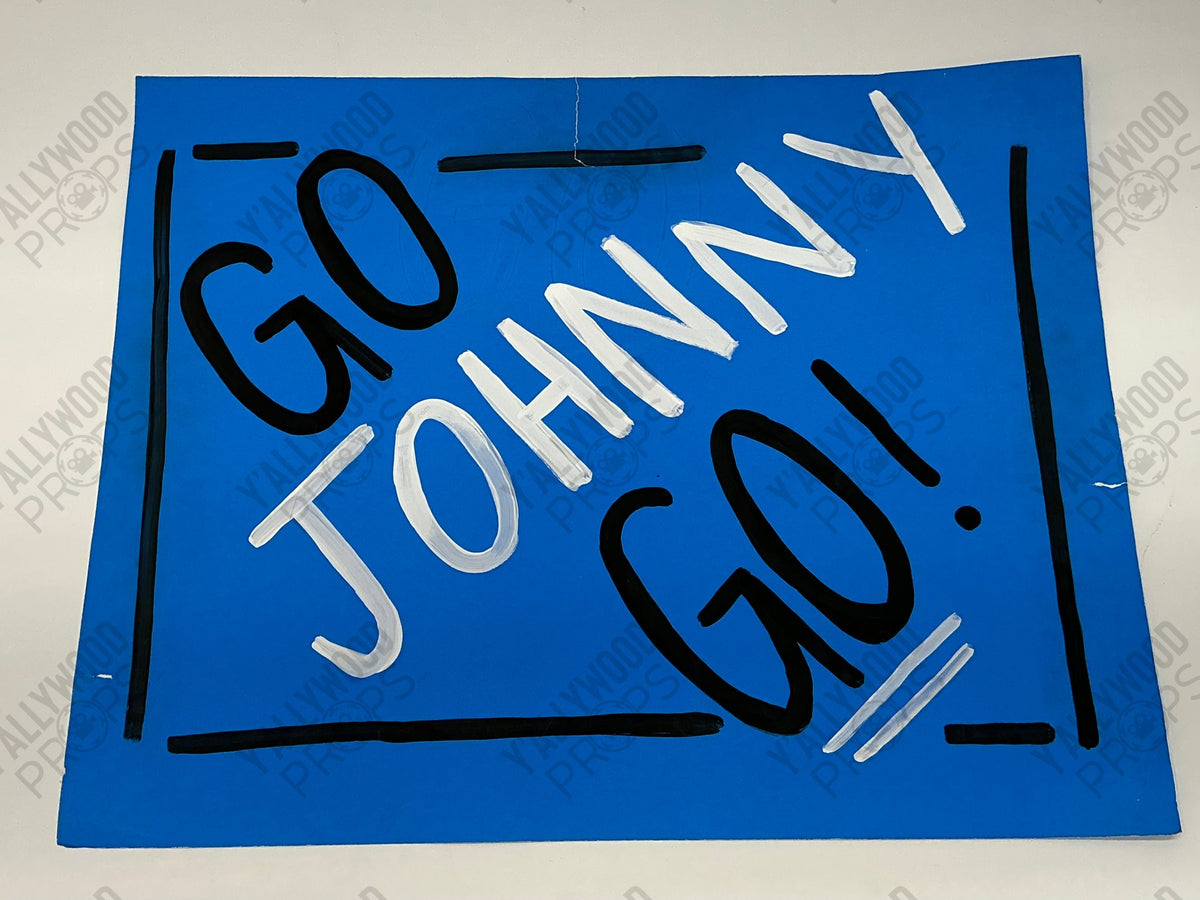 Blue cardboard fan sign with "GO JOHNNY GO" written in black and white text with hand-drawn border.