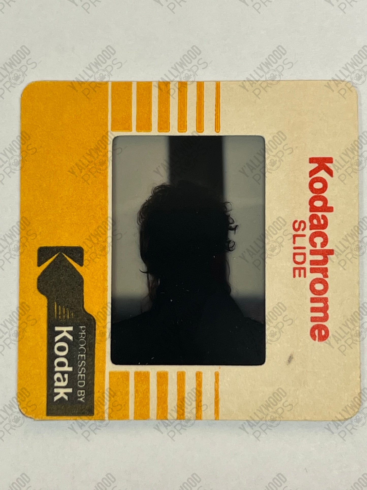 Kodachrome slide with silhouette of person against gray background, yellow and cream border with red "Kodachrome Slide" text