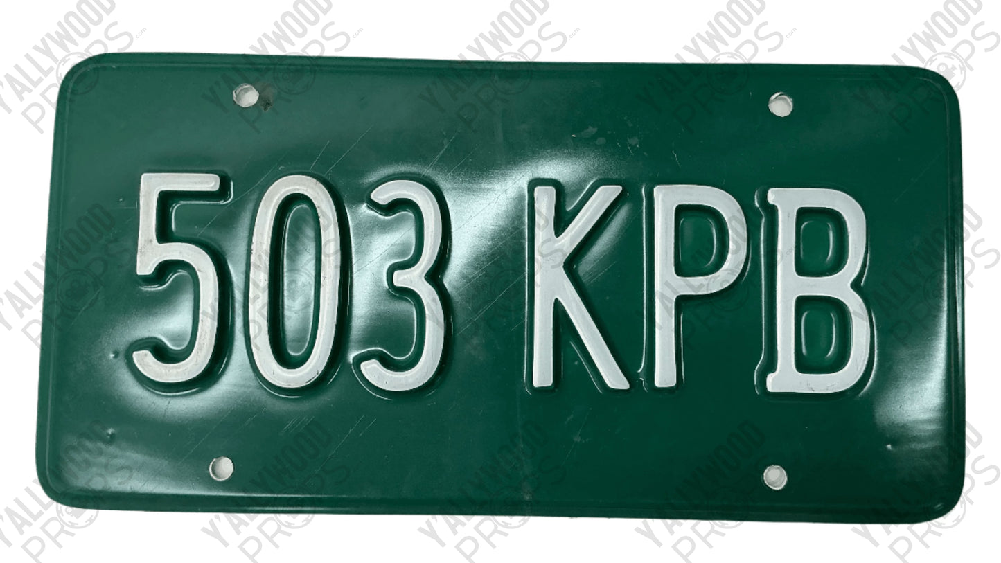 Green license plate with silver raised letters reading "503 KPB" and four mounting holes.